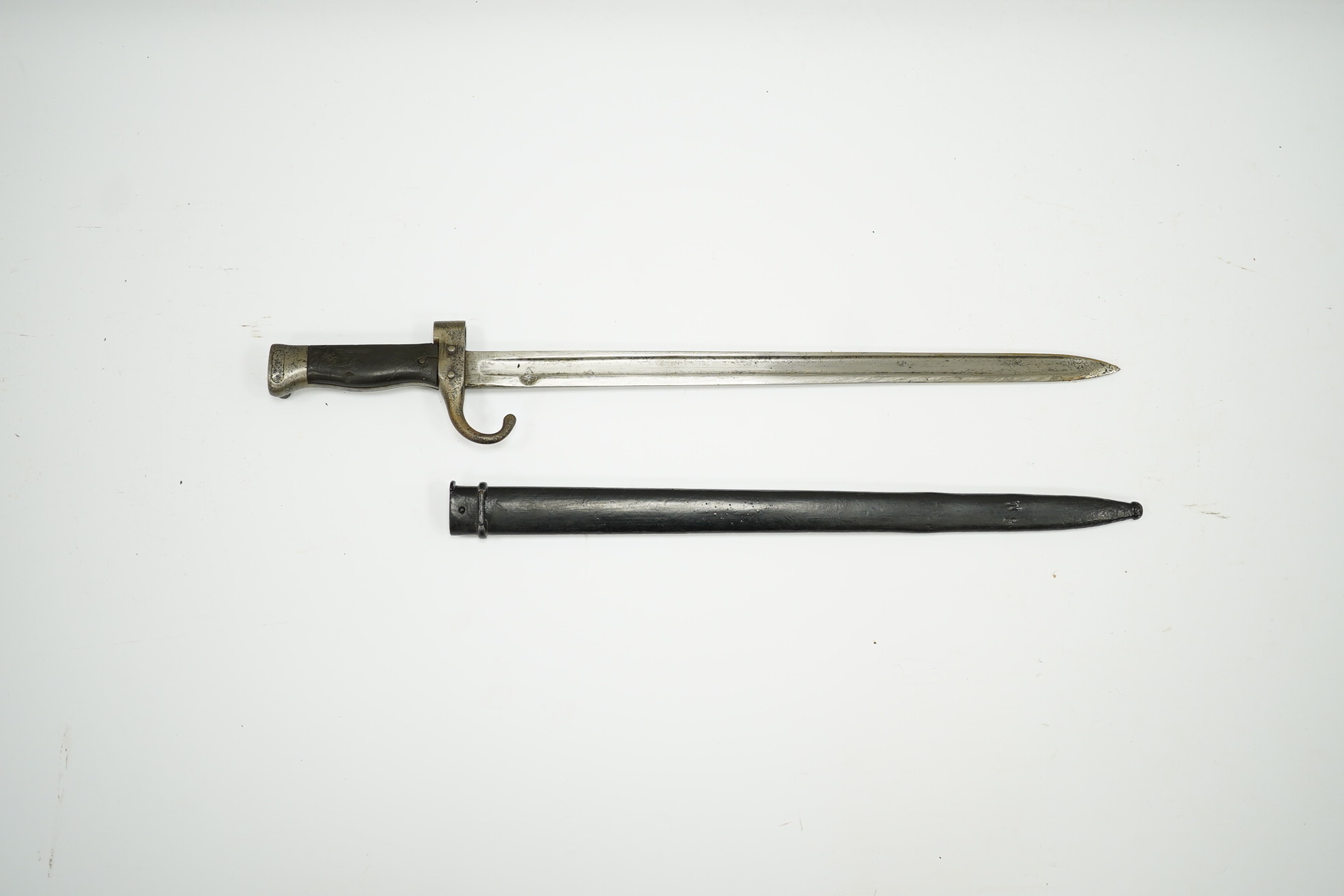 A 19th century French infantryman’s sidearm Gladius with swollen double edged blade, and regulation cast brass cruciform hilt, in its brass mounted leather scabbard, together with a continental bayonet also in scabbard.